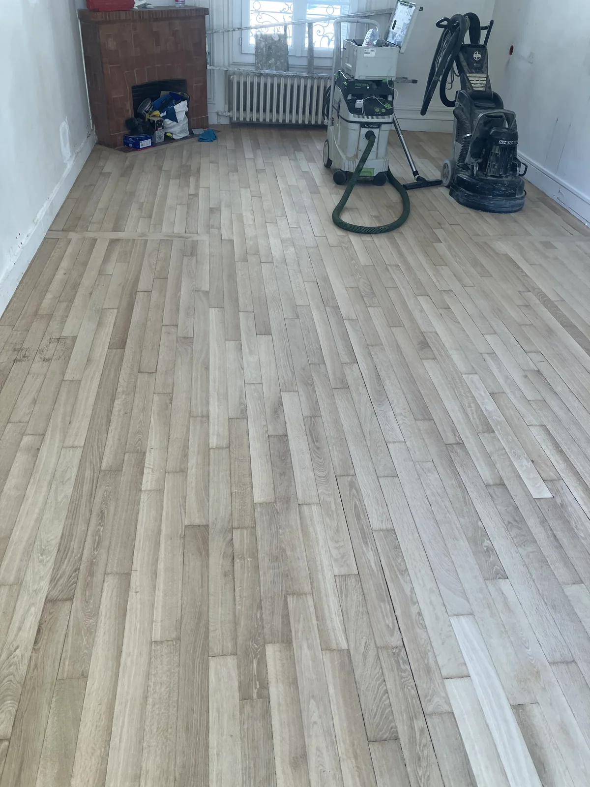 Les taches ont disparu : elles étaient dans le vernis et le premier millimètre de bois. Cheminée en brique d'origine. Porte d'Orléans, Paris 14e.