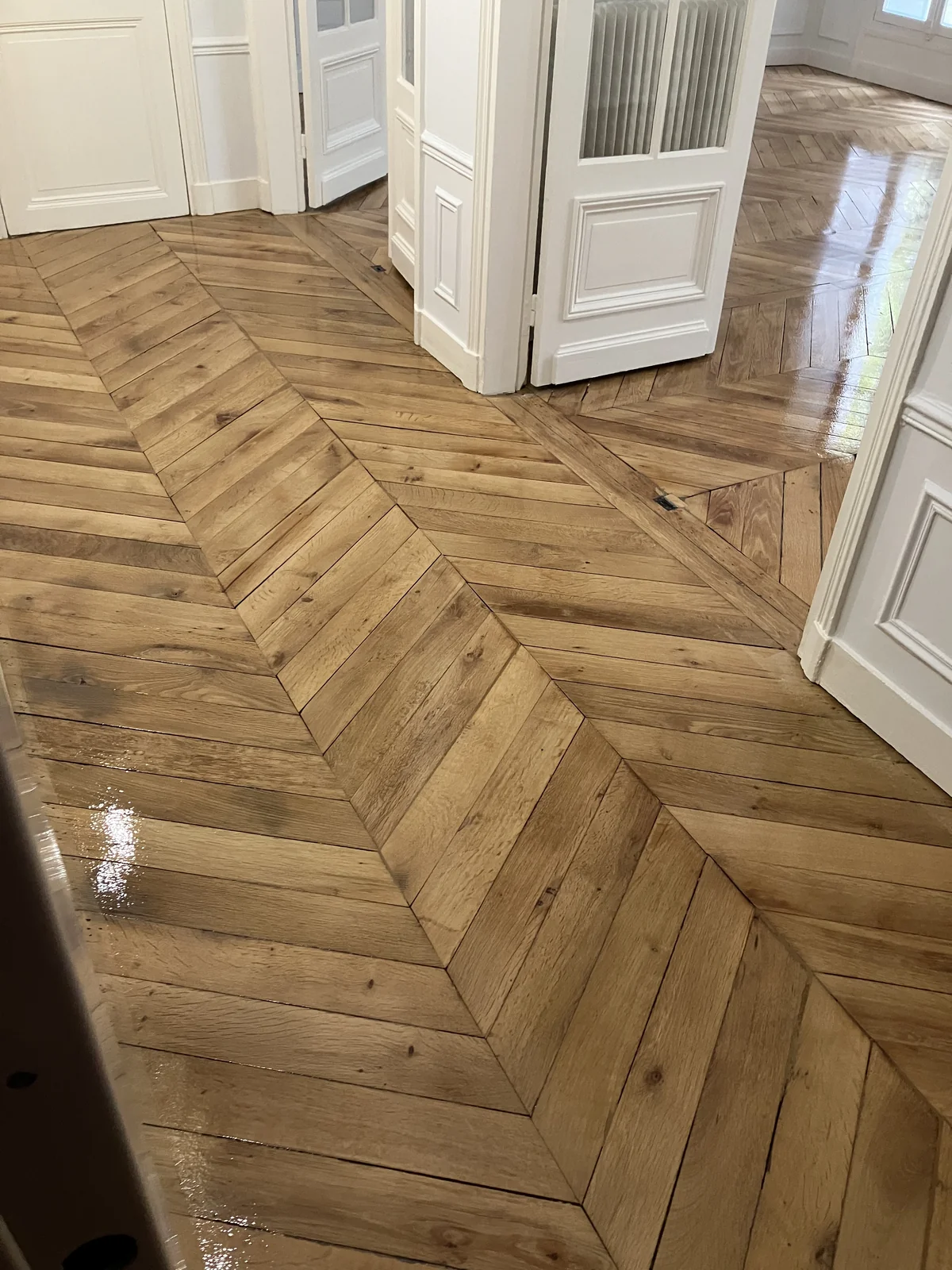 Trois couches de Bona Mega Evo. La lumière accroche différemment selon l'orientation des lames. Paris 15e.