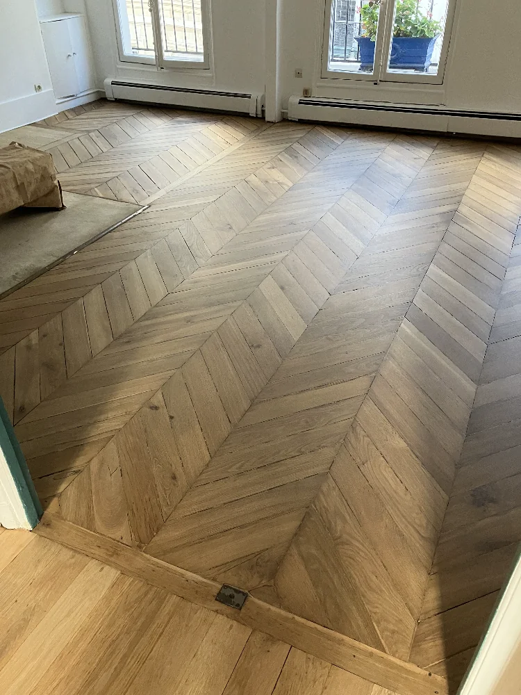 Le motif en chevrons ressort dans toute sa géométrie une fois le bois nu. Un motif que seule une machine multidirectionnelle peut poncer sans sillons.