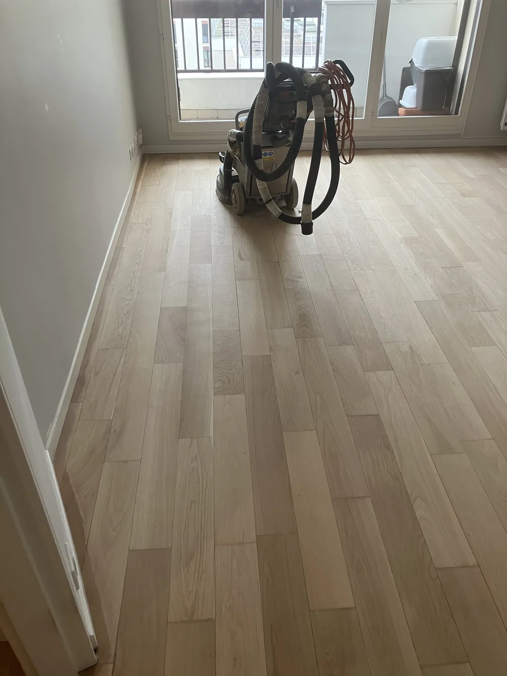 Le chêne débarrassé de son ancien vernis retrouve sa teinte naturelle, claire et mate. C'est souvent à ce moment que le client comprend ce qu'il avait sous les pieds.