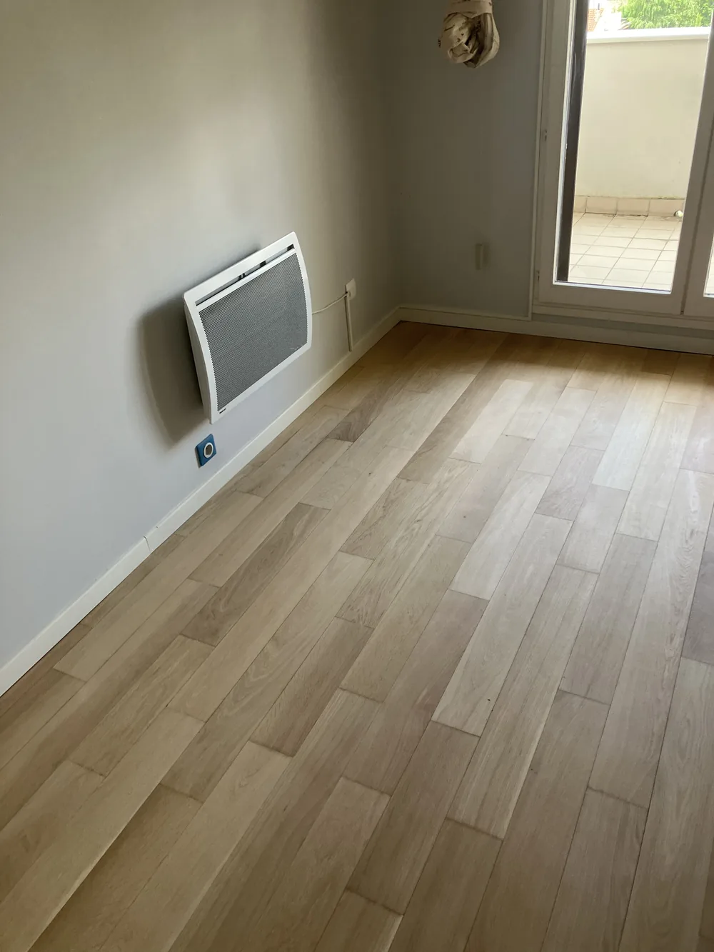 Bois nu, dépoussiéré, uniforme. C'est l'état dans lequel un parquet doit être avant la première couche — pas avant.