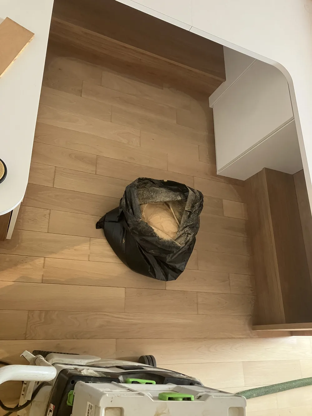 Voilà ce qui aurait fini sur les murs, les meubles et chez les voisins. L'aspirateur Festool à filtre HEPA capte la sciure directement à la sortie de la machine. Le chantier reste propre — c'est la première chose que les clients remarquent.