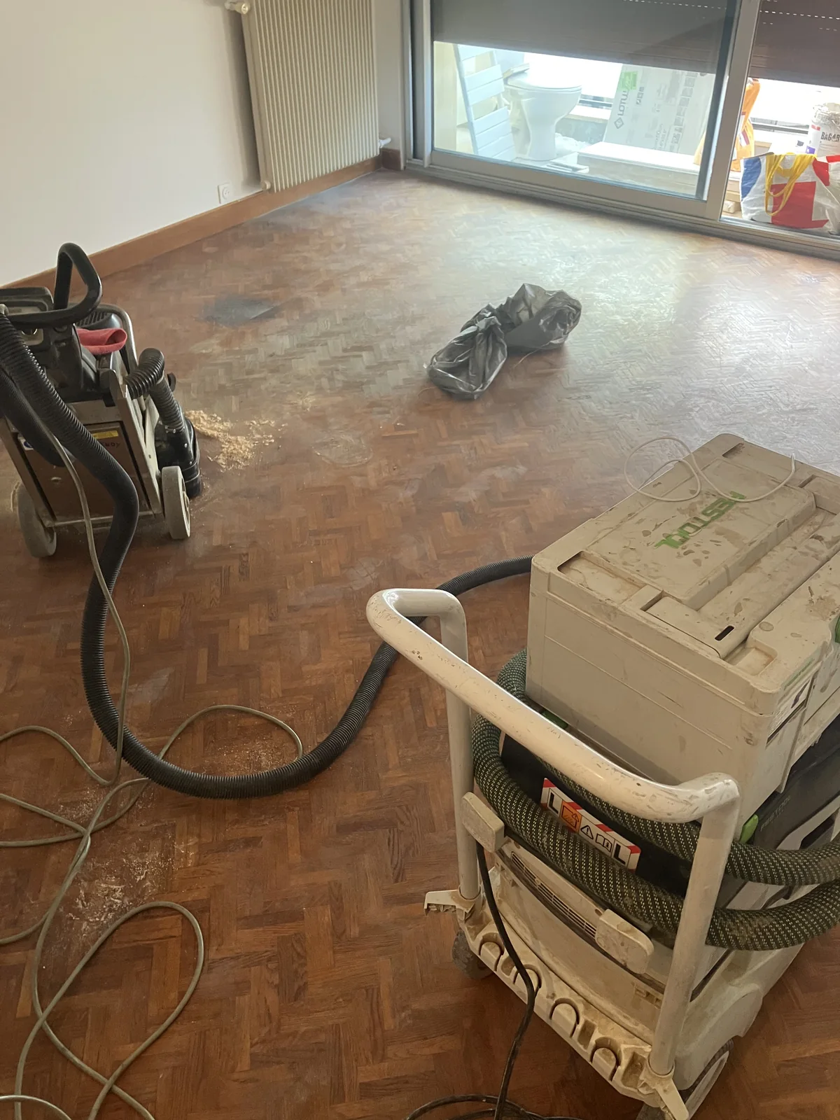 Parquet à petites lames en bâtons rompus, sous un vernis ancien terni. Vanves (92170).