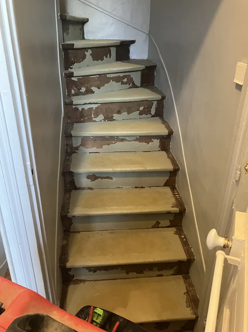 Escalier bois avant ponçage — colle de moquette et peinture écaillée sur les marches