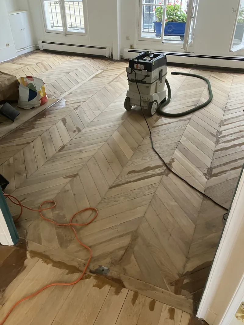 Parquet abîmé avant réparation à la pâte à bois Sintobois — Paris 7e