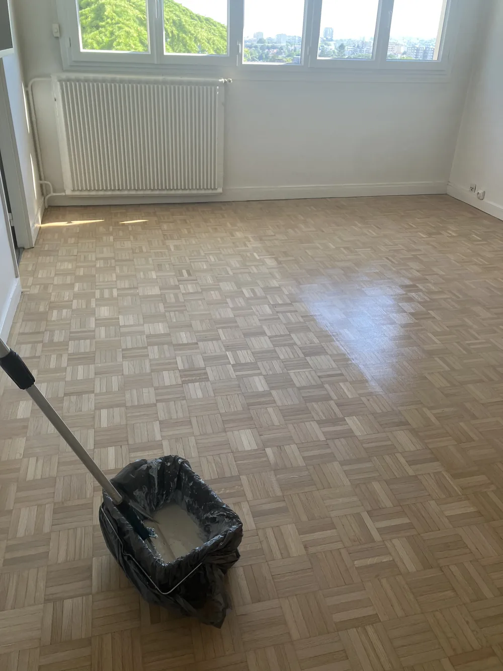 Parquet mosaïque en chêne clair. Le vernis est appliqué au spalter, en bandes régulières, sans reprise visible
